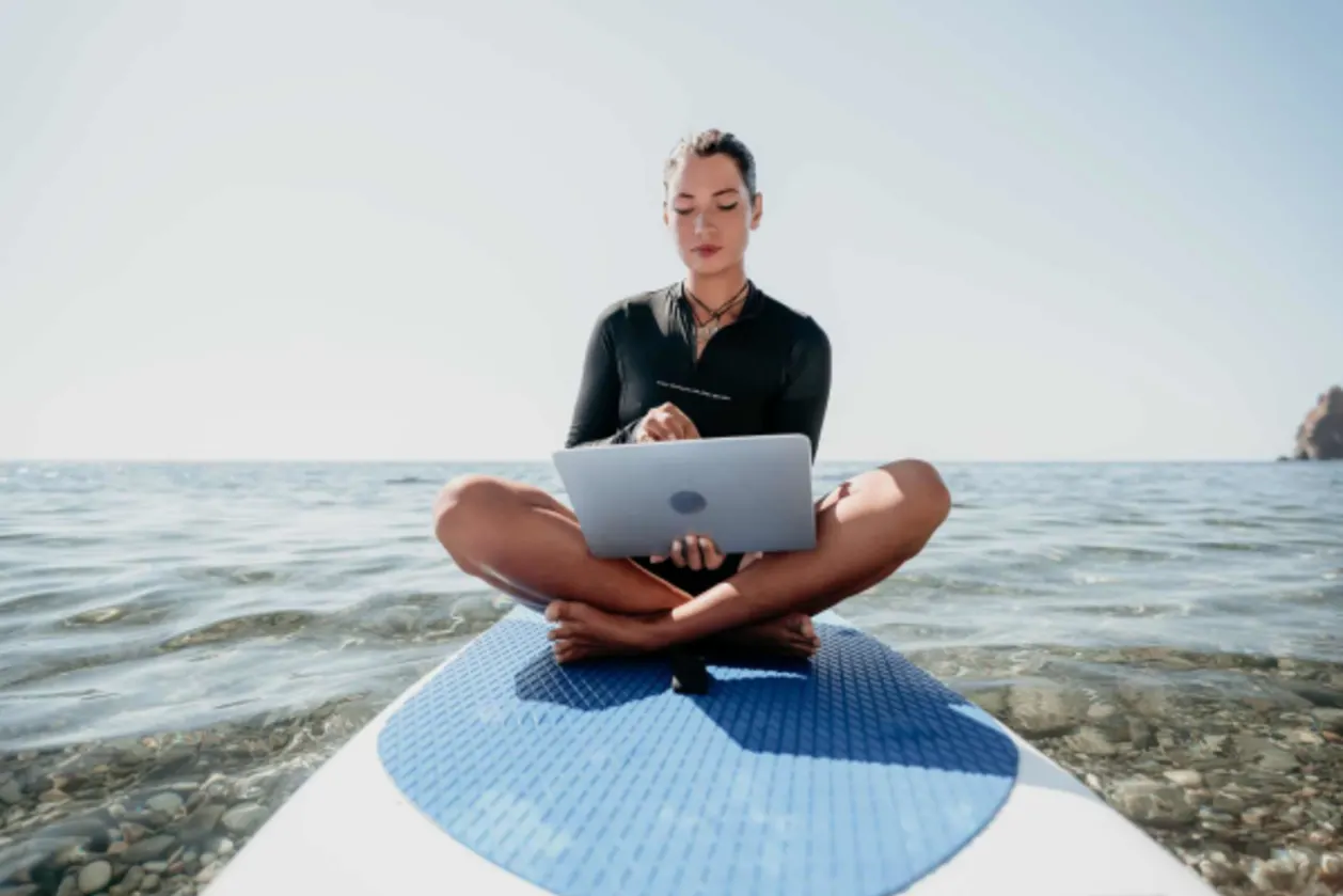 woman working on surfboard digital nomad concept